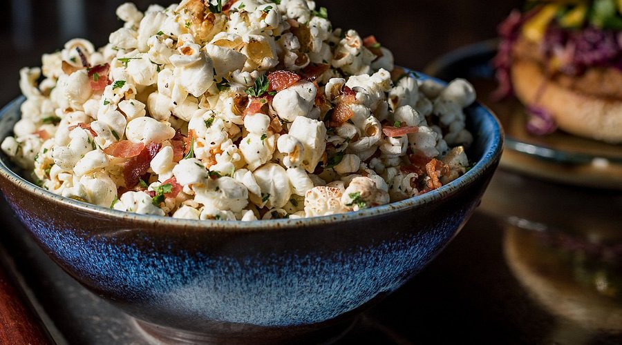 The Parish signature dishes Bacon Popcorn, The Parish Burger, Shrimp & Grits, Duck Confit, Gumbo.